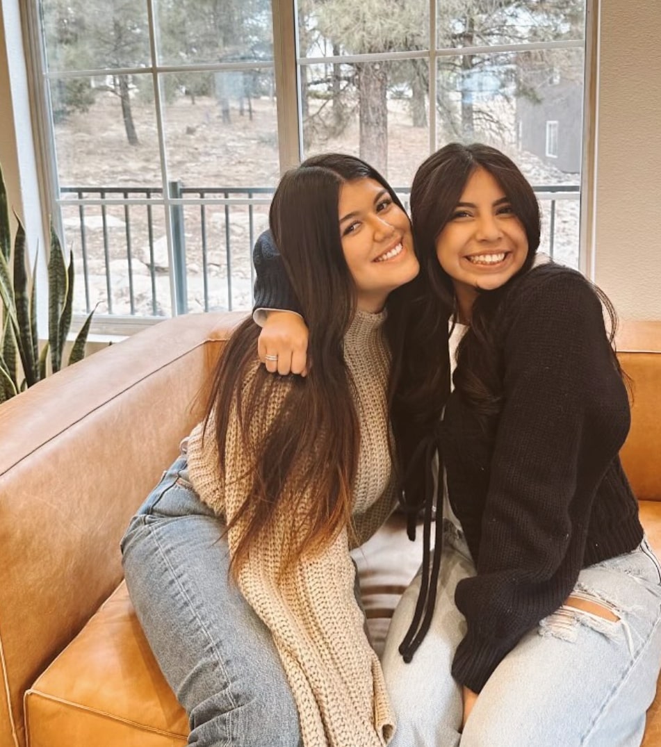 Two girls smiling and posing on couch