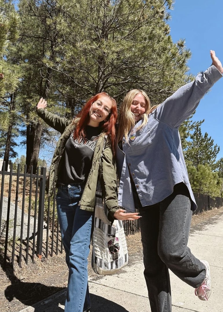 Two young women posing outsdie on sunny day